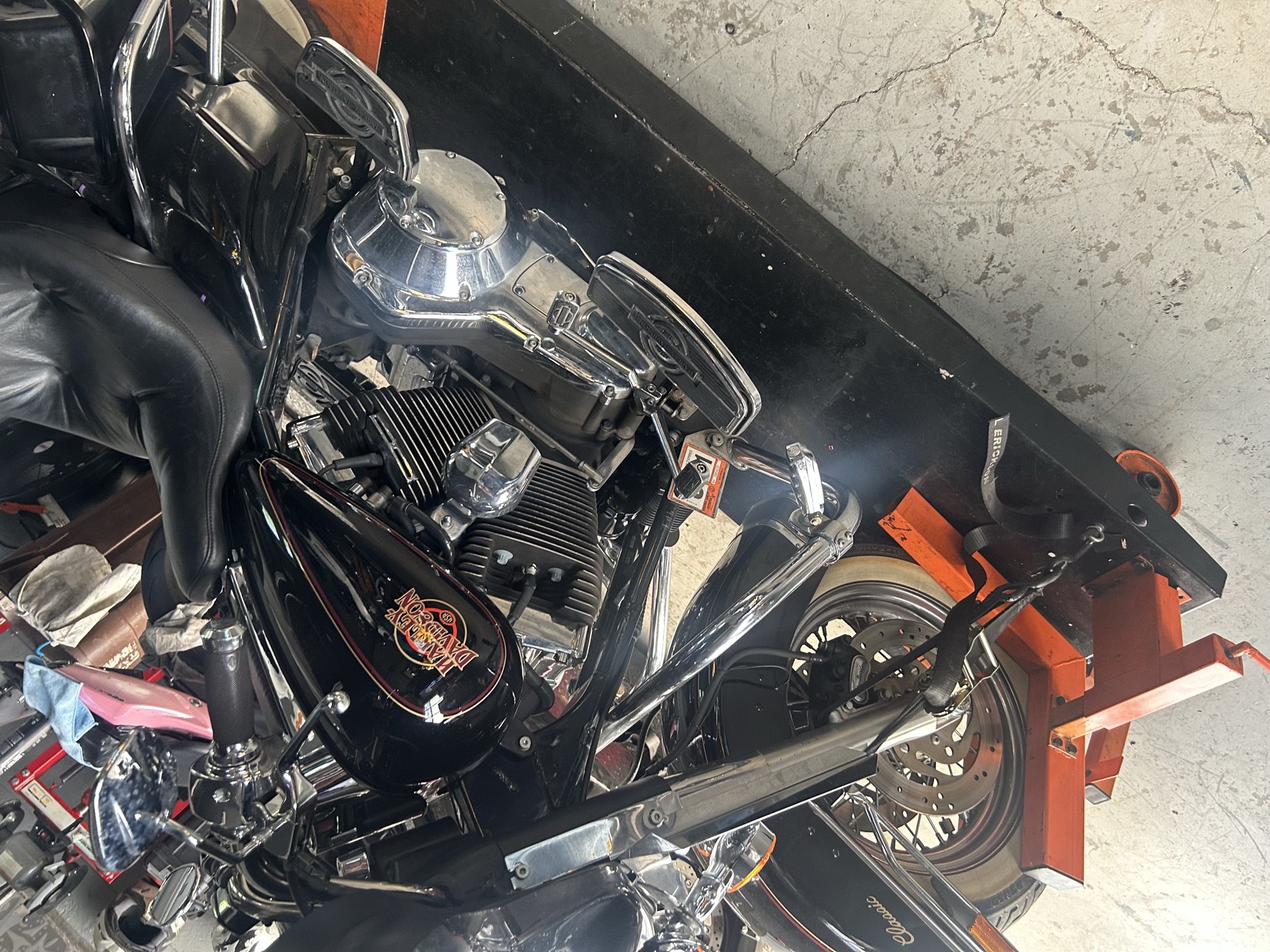 Black Harley-Davidson Classic up on the lift table inside the shop