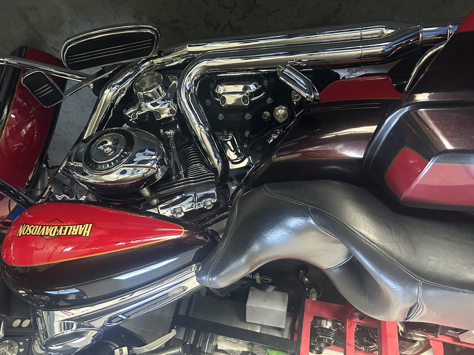 Two-tone red Harley-Davidson with chrome engine in the shop for service