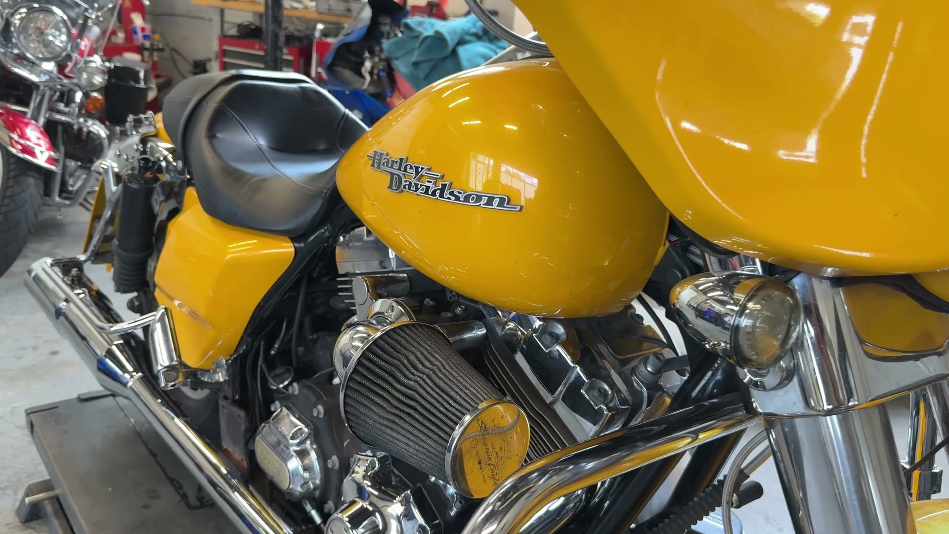 Yellow Harley-Davidson Street Glide with upgraded intake in the workshop